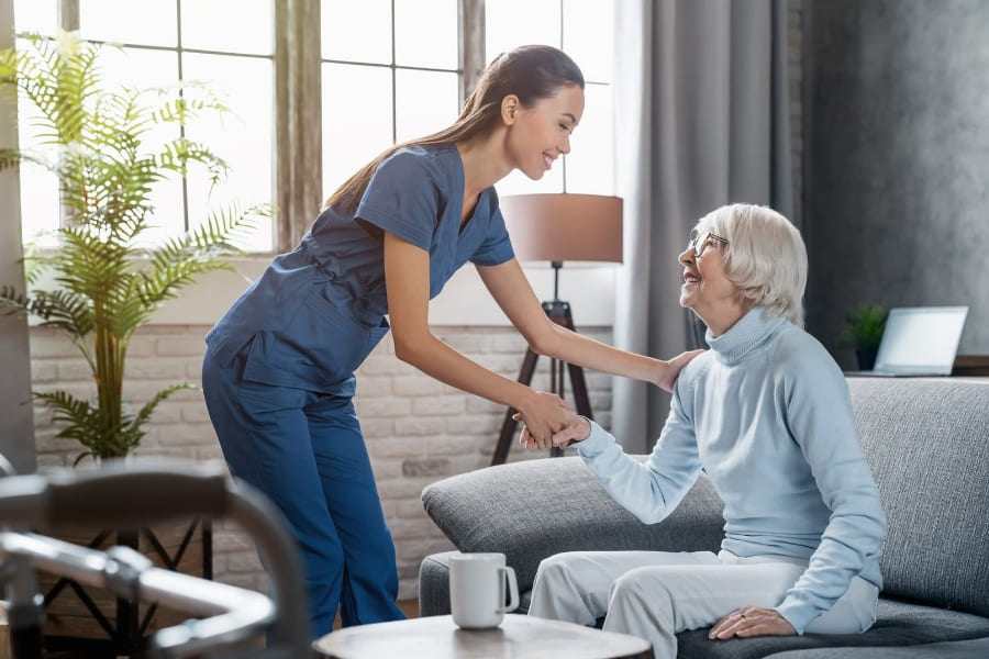 Why Families Trust Fresh Springs Care for Compassionate Home Support Female carer smiling and supporting an elderly woman in a cosy living room